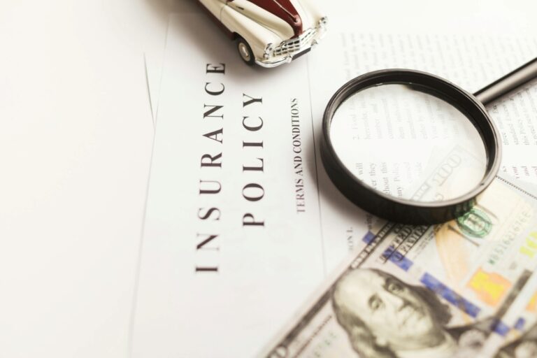 A magnifying glass on top of insurance policy papers