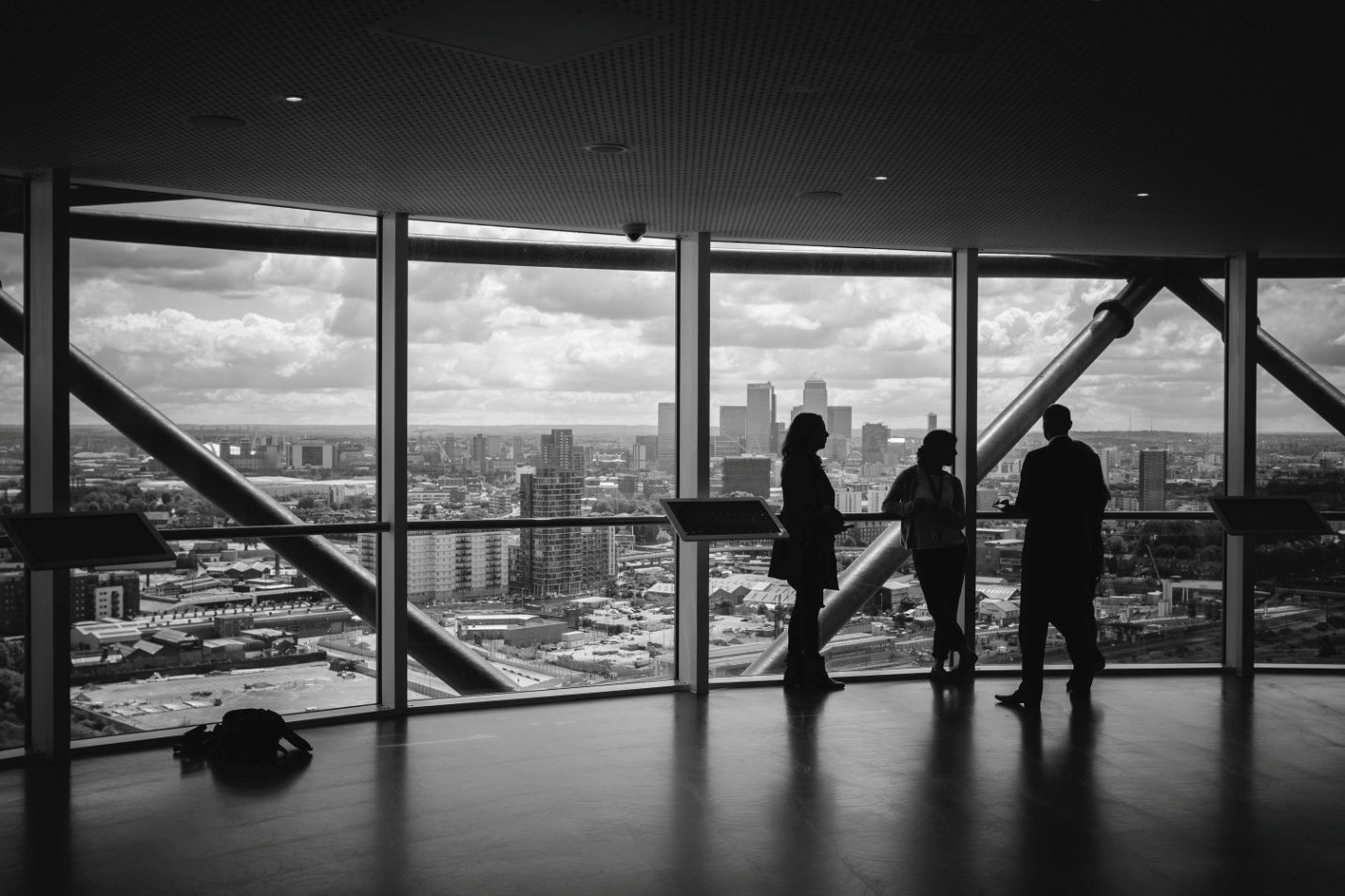 People standing near a large window in an office